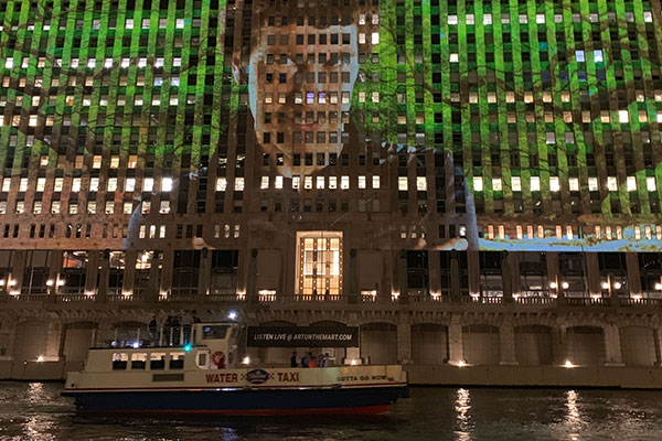 Projection on Merchandise Mart with boat passing in front