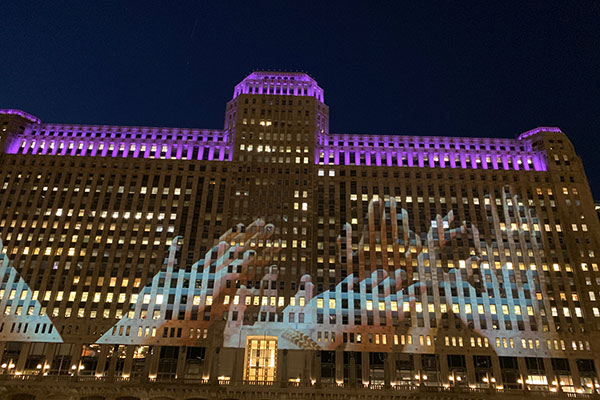 Merchandise Mart with hands projected on it