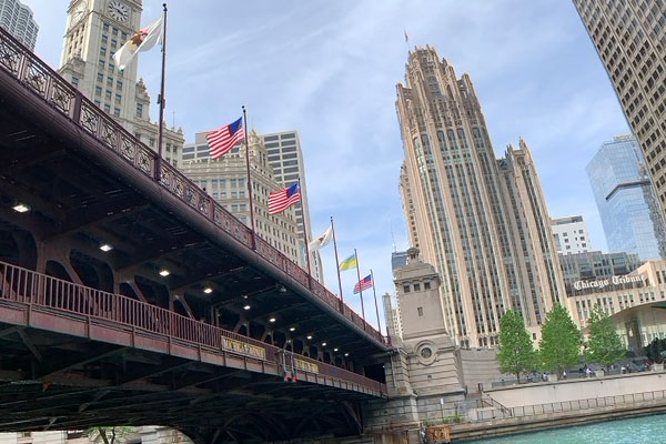 Flags flying on Michigan Avenue Bridge with the Wrigley Building and Tribune Tower in the background