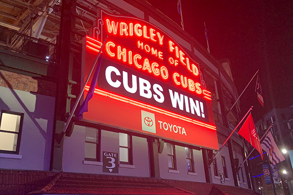 Wrigley Field Marque at night reads Cubs Win
