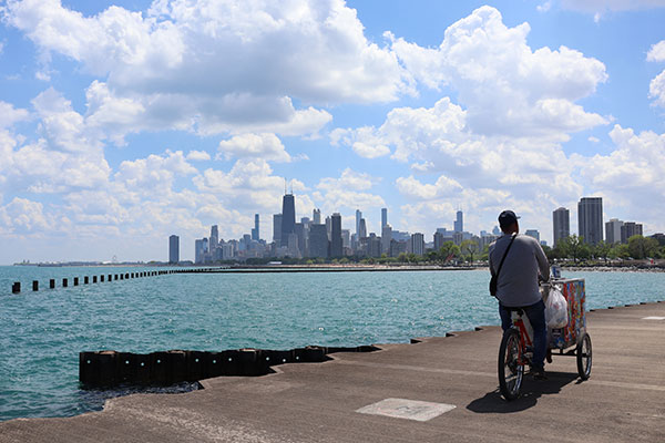 Skyline from beach while icecream man rides bike past