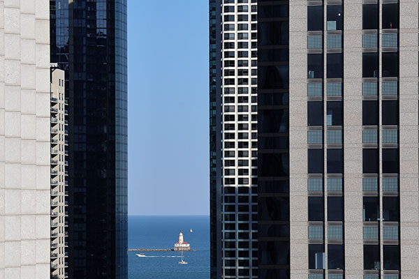 View of lighthouse in distance between buildings