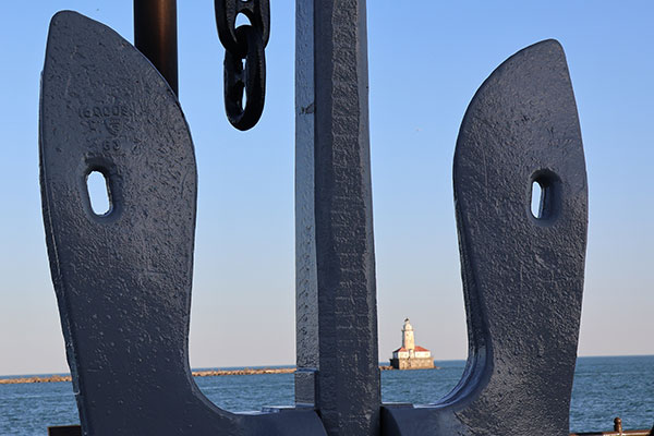 Anchor with lighthouse beyond it