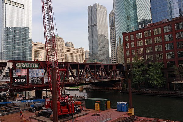 Workers working on train tracks above South Branch of Chicago River