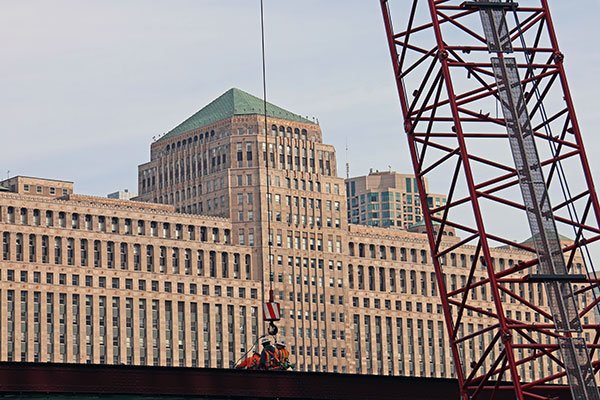 Workers working on bridge with Merchandise Mart in background