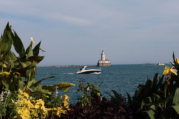 Speed boat passes lighthouse