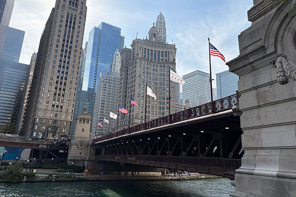 Sun shines on flags on Michigan Avenue Bridge over the Chicago River