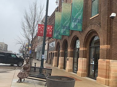 Marion Ross Performing Arts Center statue below banners