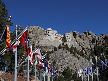 Mount Rushmore with flags in front