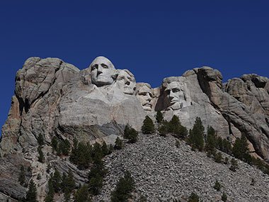 Mount Rushmore with trees and rocks on hill