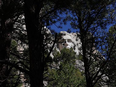 Mount Rushmore view of Abe Linoln through trees