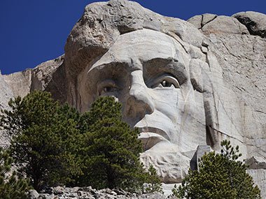 Mount Rushmore view of Lincoln behind a tree