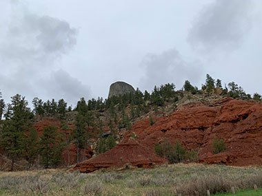 Devils Tower National Monument behind red rocks