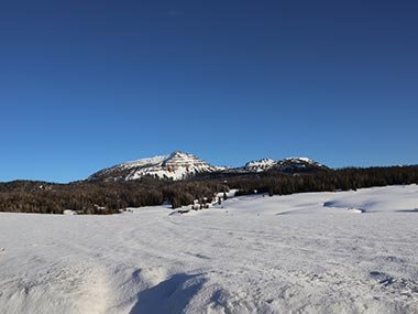 Snow covered field with mountain beyond