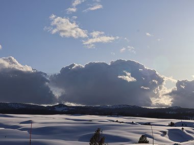White clouds over snow covered field