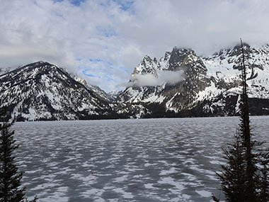 Frozen Jenny Lake beyond trees