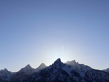 Mountain tops with setting sun behind at Grand Teton National Park