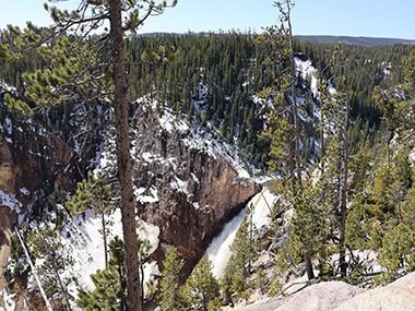 water flows over waterfall at Yellowstone National Park