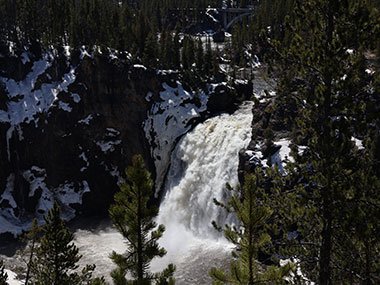 Waterfall flows over snow covered hill -Yellowstone National Park