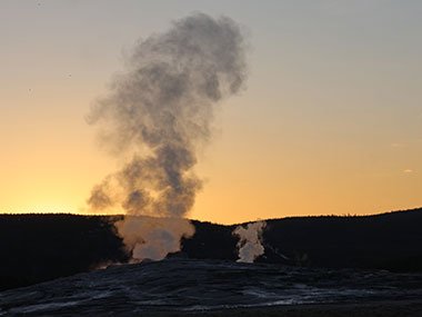 Steam rise above Old Faithful prior to sunrise