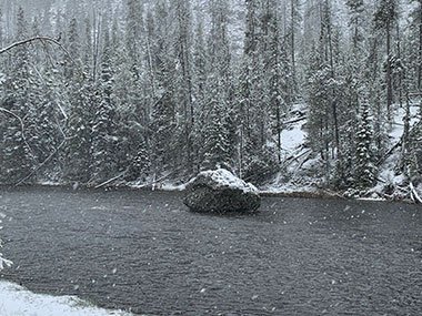 Snow falls into river