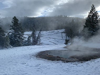 Steam rises from pool with snow on ground