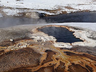 Red sediment around geyser pool in Yellowstone National Park