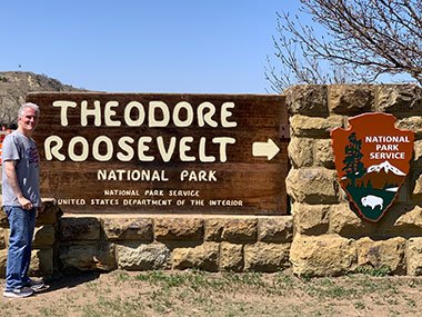 Pat in front of Theodore Roosevelt National Park sign