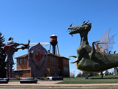 Dragon and knight statue with water tower beyond
