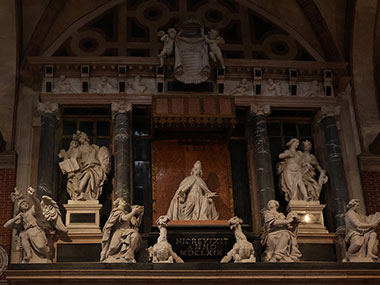 Several statues on a wall monument