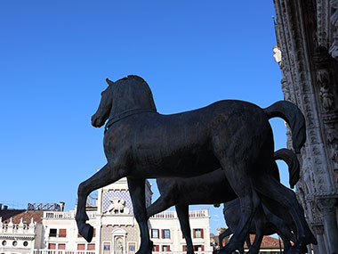 Horse statues with clock tower in background