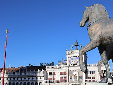 One horse statue with clock tower in background