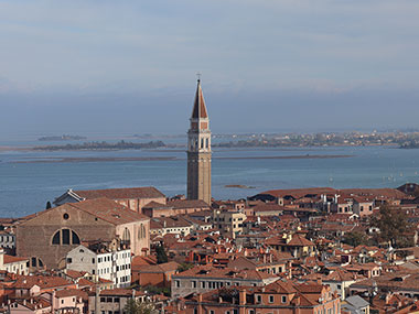 In the distance a bell tower stands ove Venice