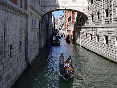 Bridge of Sighs on partial sunlight as gondola approaches