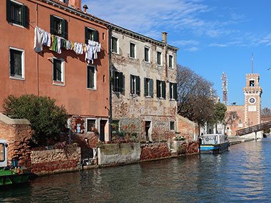 Laundry hangs from balcony along canal