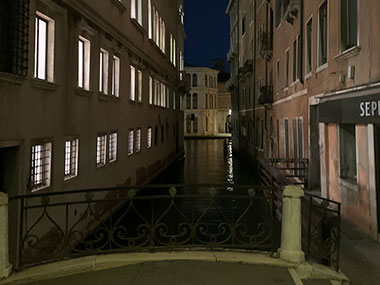 Looking down empty canal at night