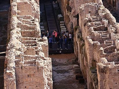 People touring floor of the Colosseum