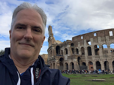 Pat smiles in front of the Colosseum