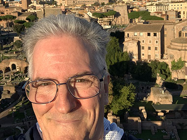 Pat in sunlight with Roman Forum behind him