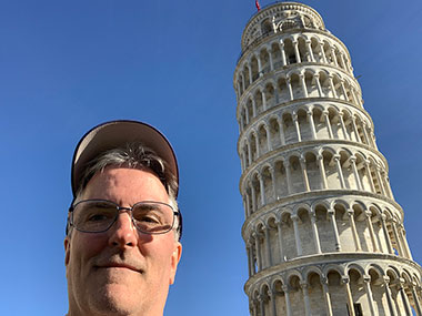 Pat smiles next to Leaning Tower of Pisa