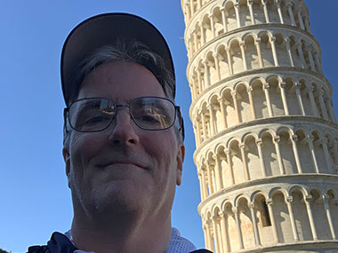 Pat in the shade next to Leaning Tower of Pisa