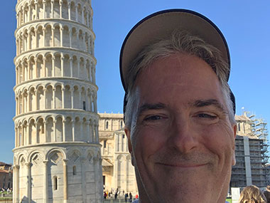 Pat smiles next to Leaning Tower of Pisa