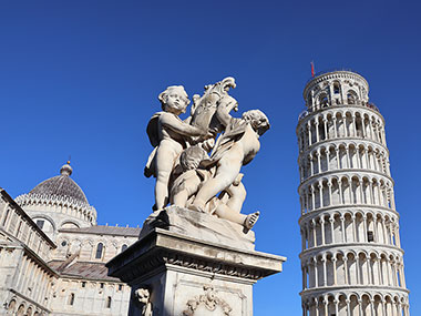 Statue in front of the Pisa Cathedral and Leaning Tower of Pisa