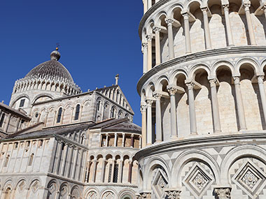 Two stories of Leaning Tower of Pisa next to Pisa Cathedral