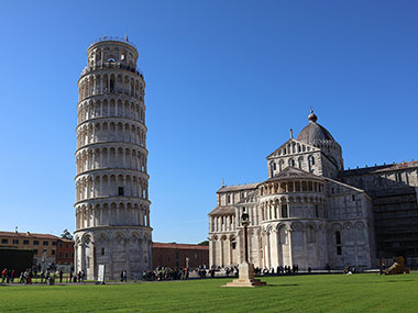 Leaning Tower of Pisa and Pisa Cathedral beyond grass area