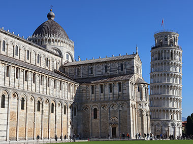 Pisa Cathedral and Leaning Tower of Pisa beyond grass area