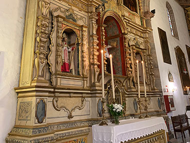 Candles burn on altar of church