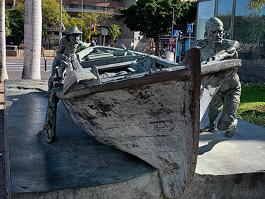 Closeup of men pushing boat statue