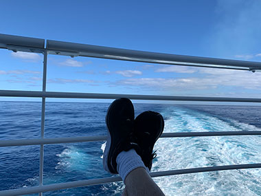 Feet up on balcony with ocean in background