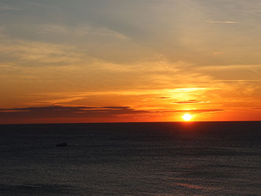 Sun setting over ocean on November 23, 2023